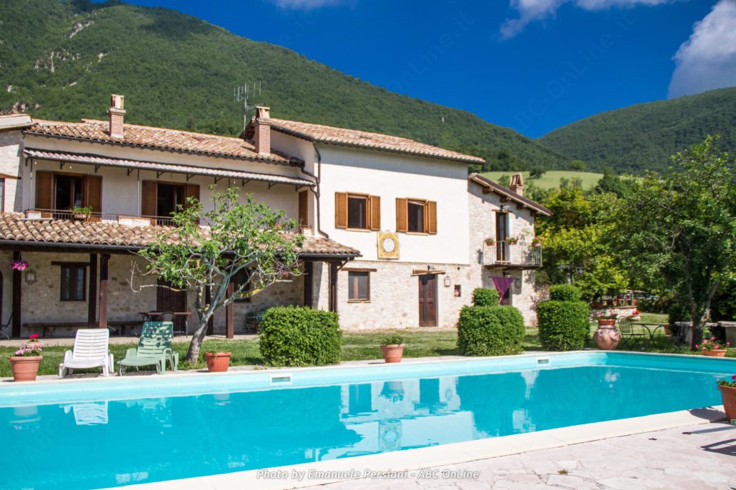 Piscina e agriturismo vista completa